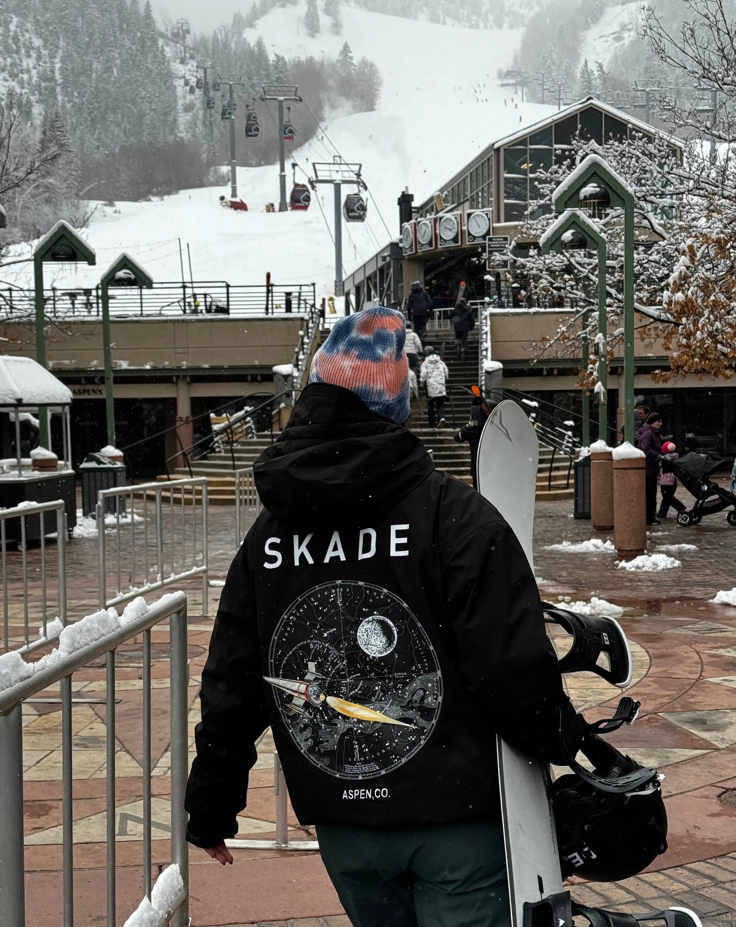 a woman carrying a snowboard down a snow covered slope